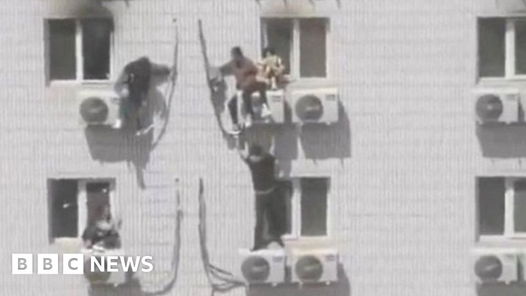 People perch on aircon units as hospital burns